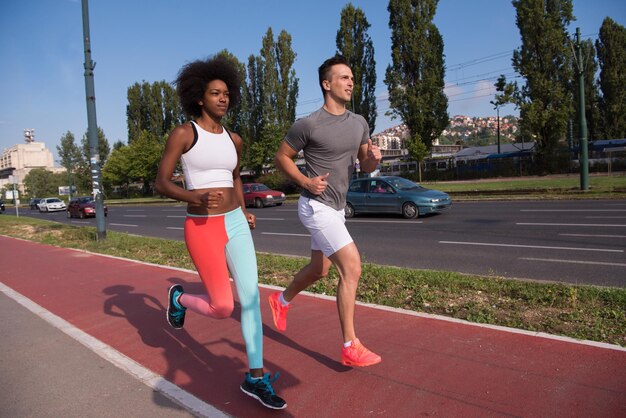 multi-etnische groep jonge mensen op de jogging mooie ochtend als de zon opkomt in de straten van de stad