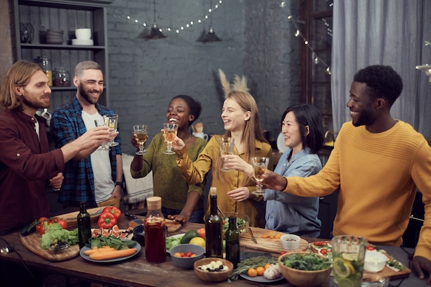 Multi-etnische groep mensen roosteren tijdens het diner