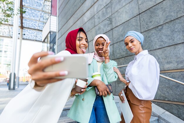 multi-etnische groep moslimmeisjes die vrijetijdskleding en traditionele hijaab dragen