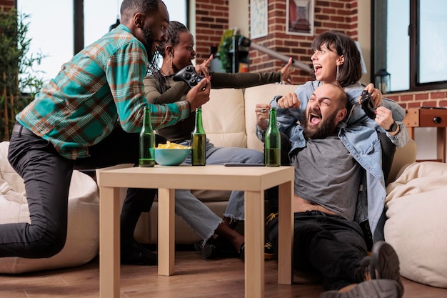 Multi-etnische groep vrienden die videogames viert tijdens het verzamelen, samen plezier hebben en genieten van de overwinning van de competitie. je blij voelen over het winnen van gameplay op de televisieconsole.