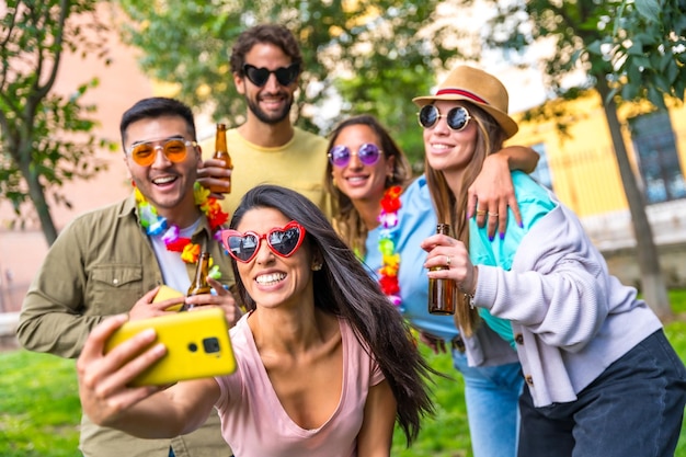 Multi-etnische groep vrienden feesten in het stadspark nemen een selfie vriendschap en leuk concept met een zonnebril op een verjaardagsfeestje