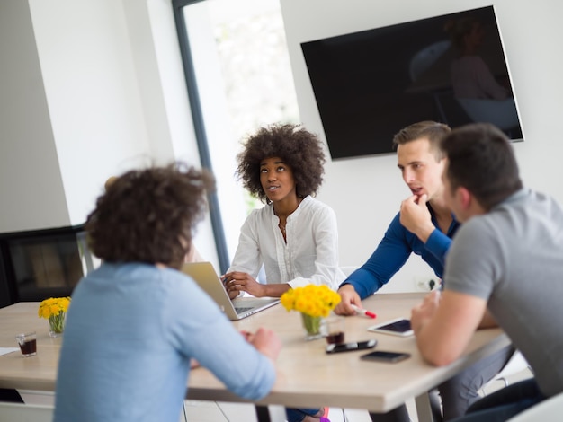 Multi-etnische groep zakenmensen die een businessplan bespreken in het startbureau