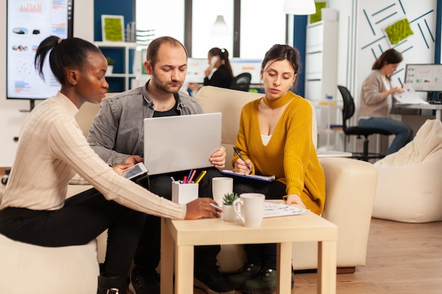 Multi-etnische groep zakenmensen in het moderne kantoor van het opstarten van bedrijven praten over het opstarten van financieel teamstrategiebeheer, het briefen van ideeën op de professionele werkplek