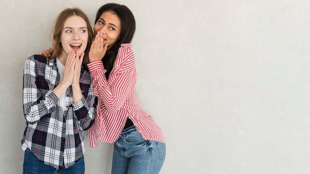 Multi-etnische jonge vrouwen die in studio roddelen