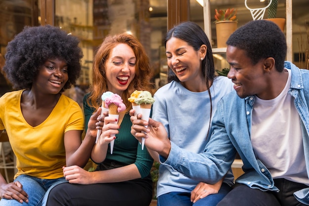 Multi-etnische vrienden in een ijssalon die een zomerse levensstijl van ijs eten en plezier hebben