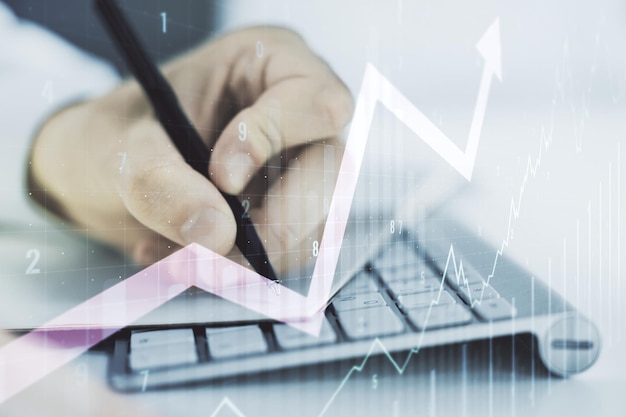 Multi exposure of abstract creative financial chart with upward arrow and hand writing in notebook on background with laptop rise and breakthrough concept