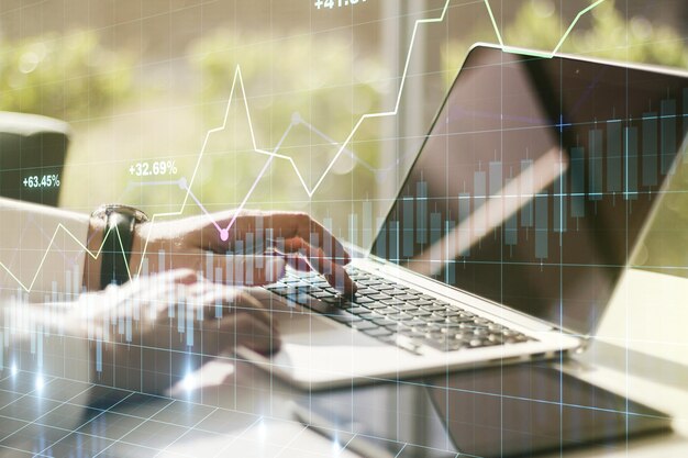 Multi exposure of abstract financial diagram with hand typing on computer keyboard on background banking and accounting concept