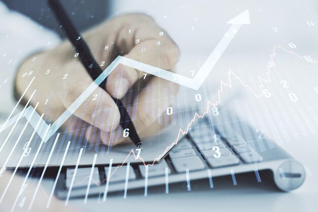 Multi exposure of abstract financial graph with upward arrow and hand writing in diary on background with laptop financial and trading concept