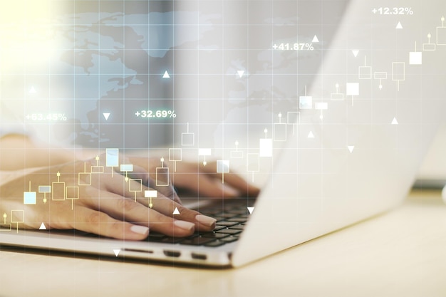 Multi exposure of abstract financial graph with world map and with hand typing on laptop on background financial and trading concept