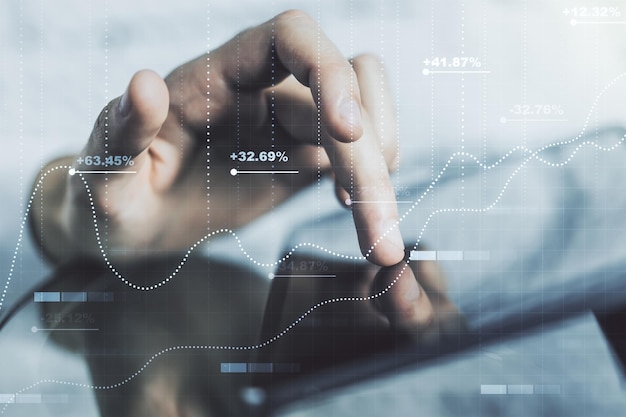 Multi exposure of abstract graphic data spreadsheet sketch and hand working with a digital tablet on background analytics and analysis concept