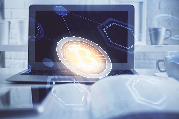 ブロックチェーンテーマのホログラムとコンピュータの背景のテーブルのマルチエクスポージャー ビットコインの暗号通貨の概念