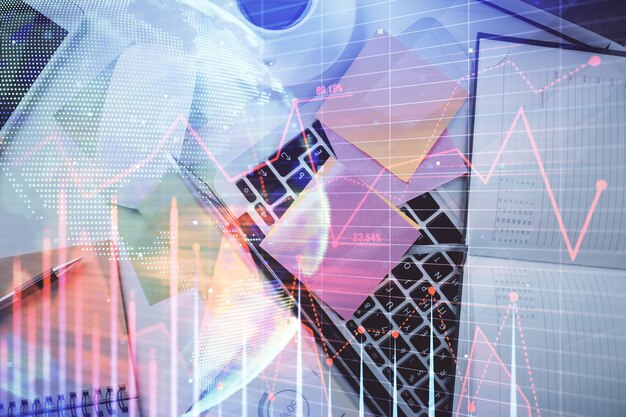 Multi exposure of financial chart drawing over table background with computer Concept of research and analysis Top view