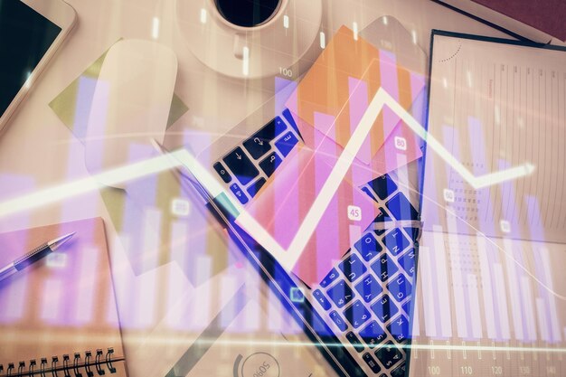 Multi exposure of financial chart drawing over table background with computer Concept of research and analysis Top view