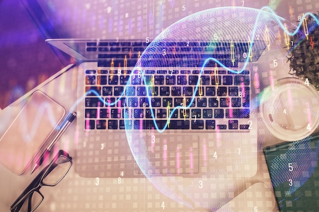 Multi exposure of financial chart drawing over table background with computer Concept of research Top view