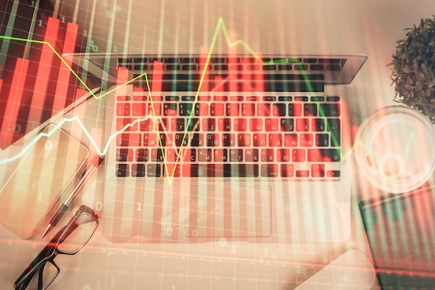 Photo multi exposure of financial chart drawing over table background with computer concept of research top view