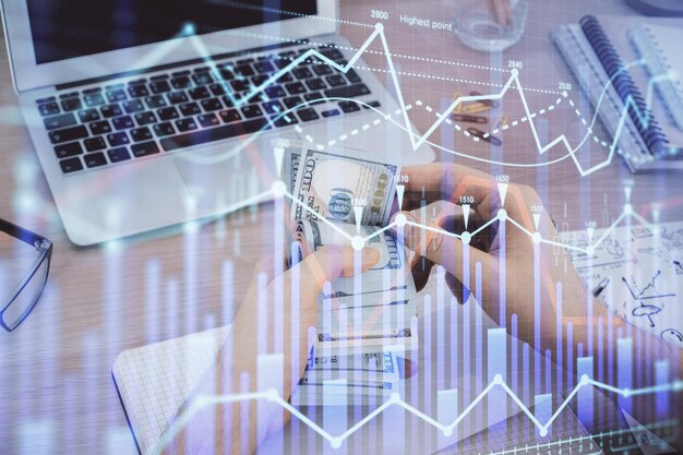 Multi exposure of financial graph drawing hologram and USA dollars bills and man hands Analysis concept