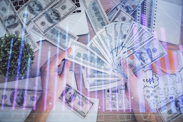 Multi exposure of financial graph drawing hologram and USA dollars bills and man hands Analysis concept