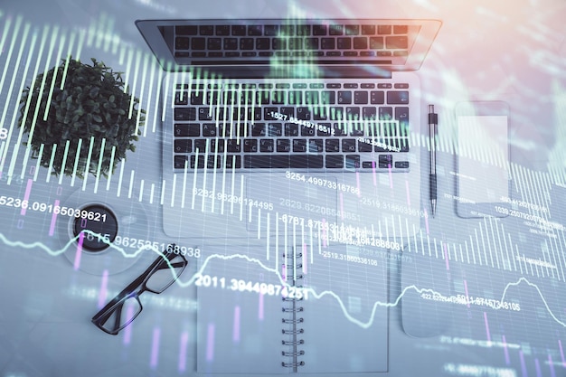 Multi exposure of forex chart drawing over table background with computer Concept of financial research and analysis Top view