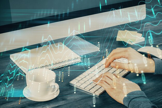 Multi exposure of graph with man typing on computer in office on background Concept of hard work