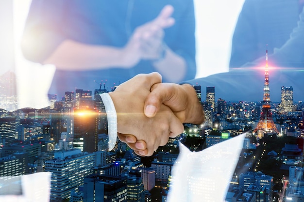 Multi exposure investor business man shaking hand with partner for successful meeting with city