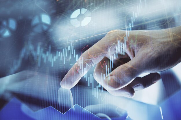 Multi exposure of man's hands holding and using a digital phone and forex graph drawing Financial market concept