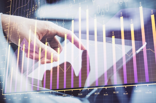 Multi exposure of man's hands holding and using a phone and financial chart drawing Market analysis concept