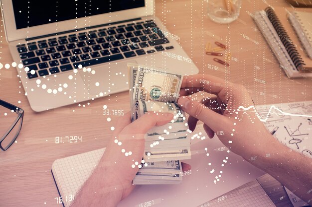 Photo multi exposure of technology drawing hologram and us dollars bills and man hands data concept