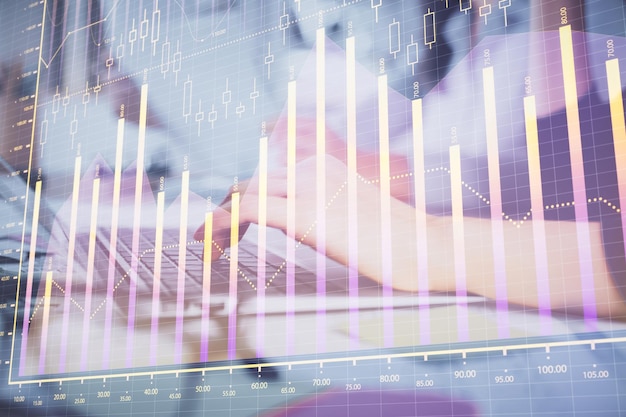 Multi exposure of woman hands typing on computer and financial graph hologram drawing Stock market analysis concept