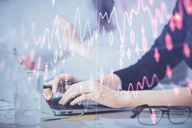 Multi exposure of woman hands typing on computer and financial graph hologram drawing Stock market analysis concept