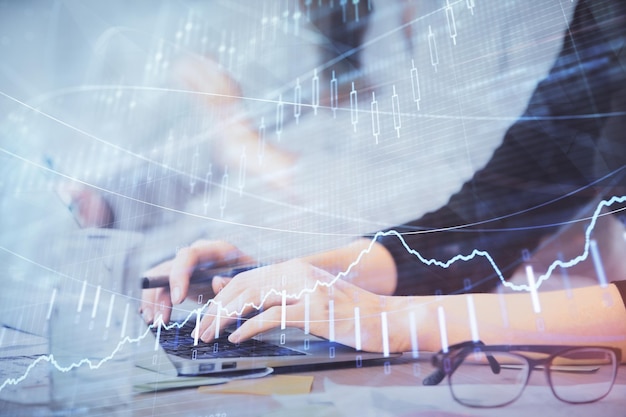 Multi exposure of woman hands typing on computer and financial graph hologram drawing Stock market analysis concept