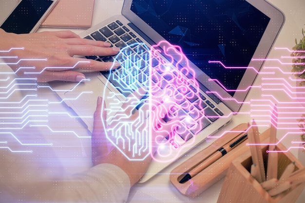 Мультиэкспозиция женских рук, работающих на компьютере, и голограмма мозга, рисующая концепцию Ai