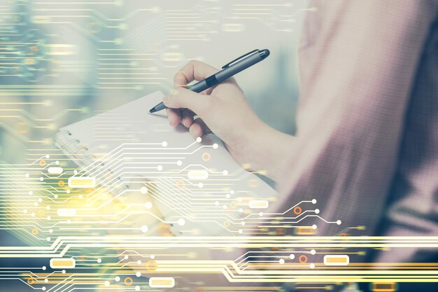 Multi exposure of woman's writing hand on background with data technology hud Concept of innovation