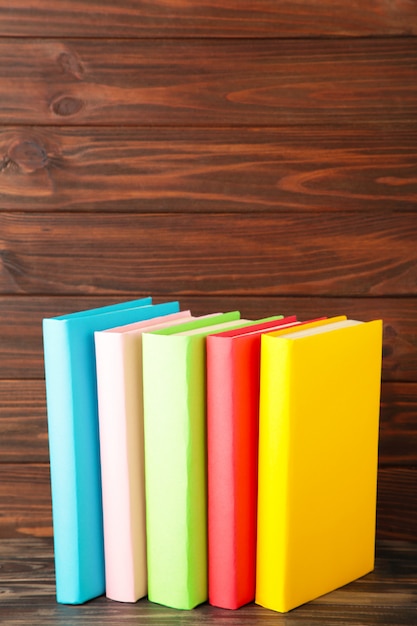 Multi gekleurde schoolboeken op een bruin hout met kopie ruimte. Terug naar school