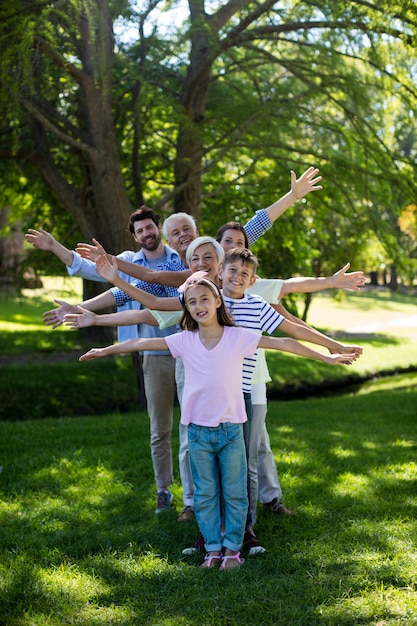 Multi generatie familie staan in een rij met uitgestrekte armen