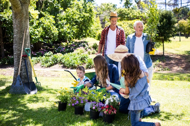 Famiglia di diverse generazioni che fa il giardinaggio nel parco