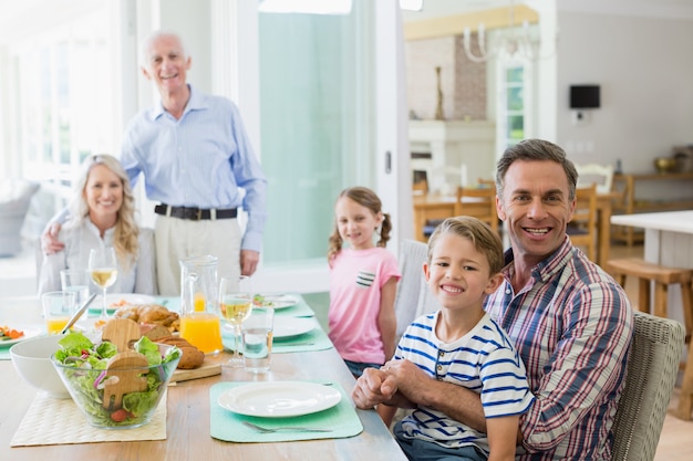Семья нескольких поколений обедает дома за обеденным столом