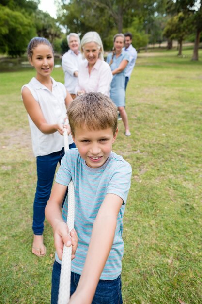 Multi-generation family pulling a rope in tug of war