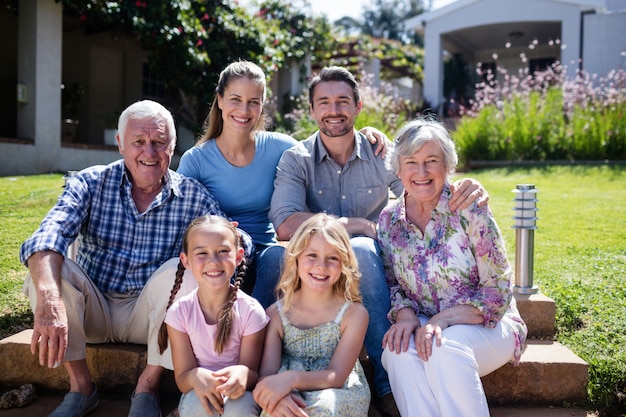 Famiglia di diverse generazioni che si siede nel giardino