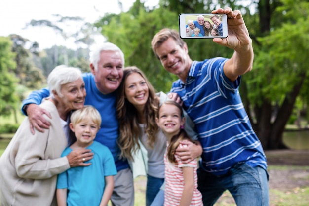 Famiglia di diverse generazioni che prende un selfie nel parco