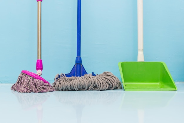 Foto multi-kleur bezems en dustpan op de vloer thuis
