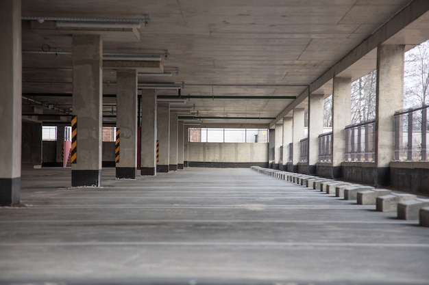 Multi-level parking with bright markings in the daytime with empty parking spaces, with columns and pavement tiles