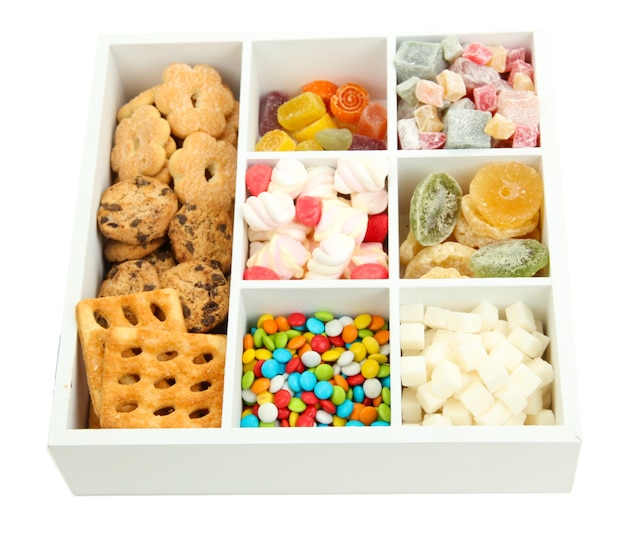 Multicolor candies and cookies in white wooden box close up