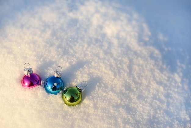 Multicolor Christmas balls in White snow blurred snow background copy space