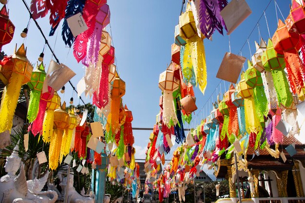 Lampada di carta colorata multicolore tradizionale stile lanna yee peng o lanterna di illuminazione tung appendere per il rispetto delle persone che pregano all'aperto nel tempio wat pa daraphirom nella città di mae rim a chiang mai thailandia