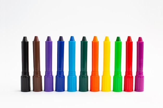 白い背景の上のプラスチックケースで着色するための多色クレヨン鉛筆。