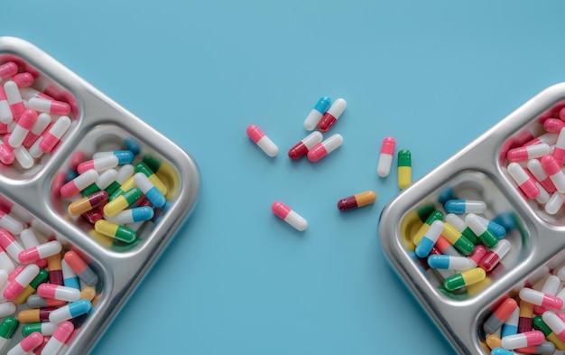 Multicolored antibiotic capsule pill on tray and blue background Antibiotic drug resistance