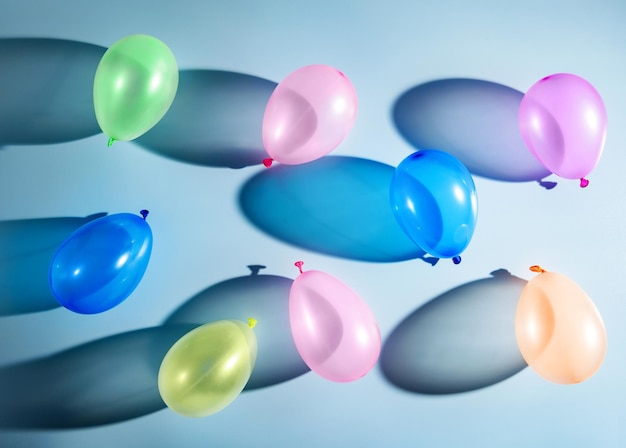 Multicolored balloons on a blue background with shadows