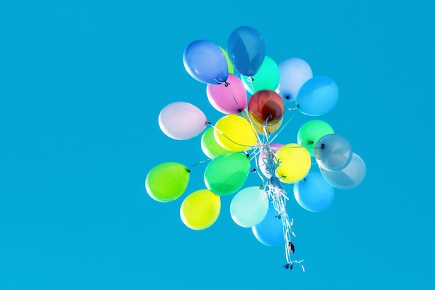 Palloncini multicolori che volano nel cielo blu. evento festivo