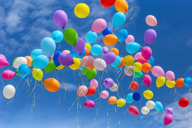 Multicolored balls released into the blue sky