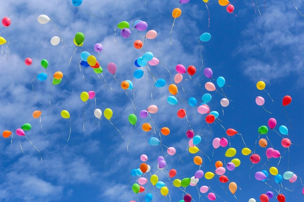 Multicolored balls released into the blue sky